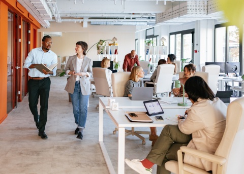 Colleagues in an open office discussing supply chains and logistics