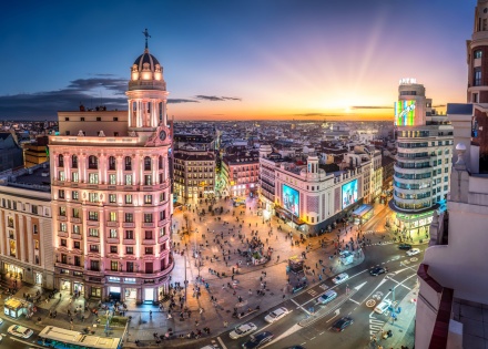 Madrid Gran Via during sunset showcasing illuminated historic building
