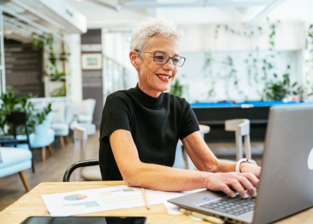 Senior woman working in modern office using laptop