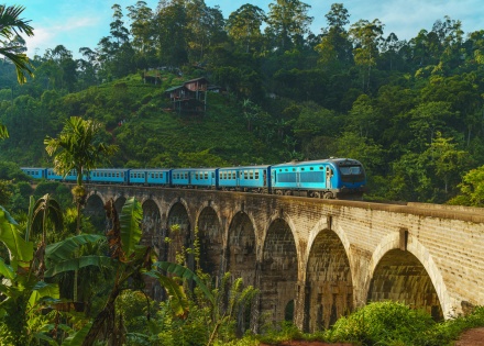 Blue train crossing the Nine Arch Bridge in Sri Lanka