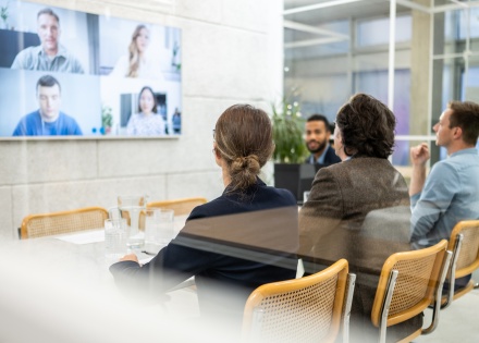 A small HR team uses video conferencing to virtually hire four cross-border employees