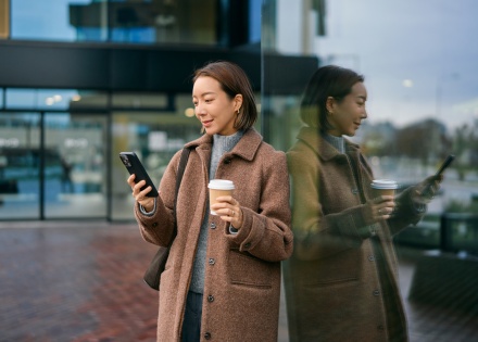 Woman using her smartphone and drinking coffee in Equatorial Guinea