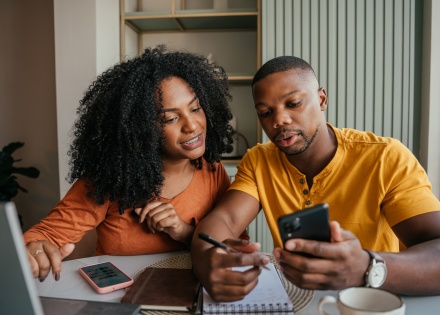 Young couple looking at phone discussing payroll taxes in Togo