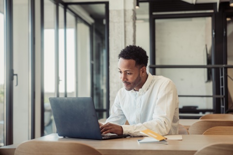 Young man using his laptop while working in his office